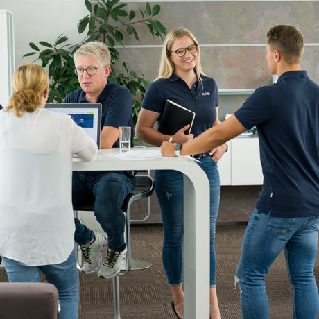 5 SGS-Teammitglieder bei einer Besprechung am Stehtisch stehend
